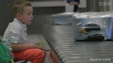 一个小孩在机场拿着行李坐在传送带旁看着人们取行李